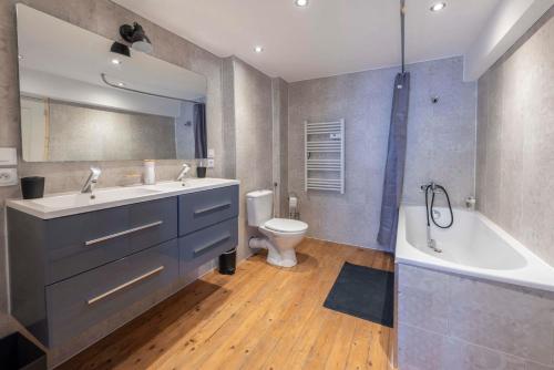 a bathroom with a sink and a tub and a toilet at Agréable maison de ville in Vincelles
