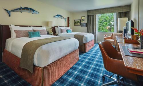 a hotel room with two beds and a desk at Graduate by Hilton Charlottesville in Charlottesville