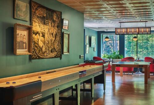 a dining room with tables and a large painting on the wall at Graduate by Hilton Charlottesville in Charlottesville
