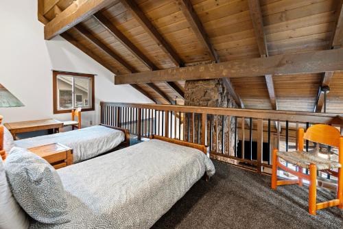 Un dormitorio con dos camas en una habitación con techos de madera. en Landrise 10 - Meredith Lodging, en Sunriver