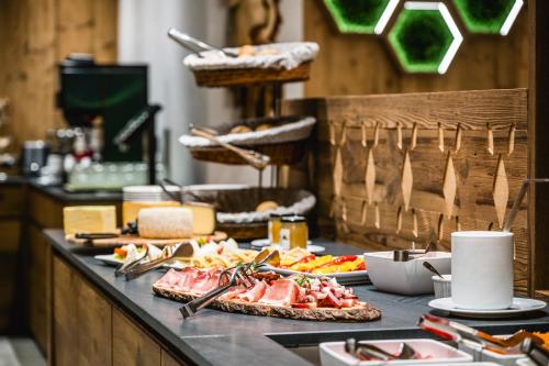 a buffet with meat and other food on a table at Hotel Vernel in Santa Cristina in Val Gardena