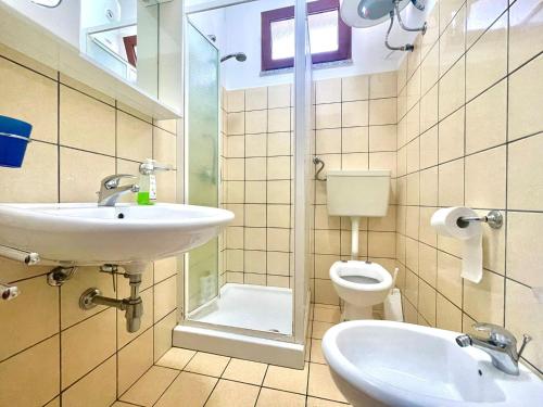 a bathroom with a sink and a toilet at Sea Breeze Home in Lotzorai