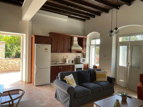 a living room with a couch and a kitchen at Portokalia in Mystras