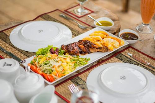 a table with plates of food on a table at Sigiriya Cottage in Sigiriya