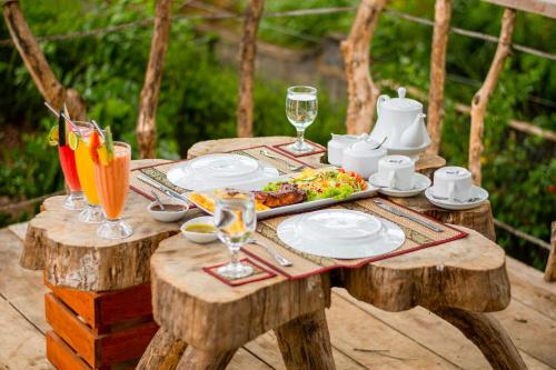 a wooden table with a plate of food on it at Sigiriya Cottage in Sigiriya