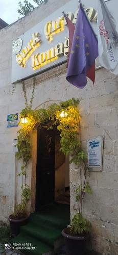 a building with a sign and an umbrella at Şark Çırağan Konak Boutique Hotel in Urfa