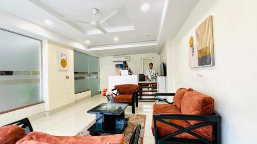 a living room with two chairs and a table at OLIVE Service Apartments Golf Course Road Gurgaon in Gurgaon