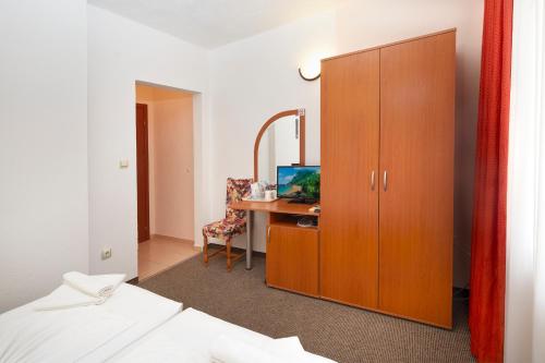 una camera da letto con una scrivania e un mobile con uno specchio di Nirvana Guest House a Nesebar