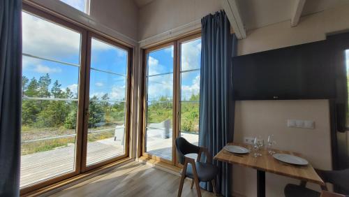 a room with a table and chairs and a large window at Seaside Tiny Maheri in Keibu