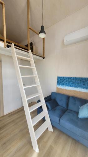 a room with a bunk bed and a blue couch at Seaside Tiny Maheri in Keibu