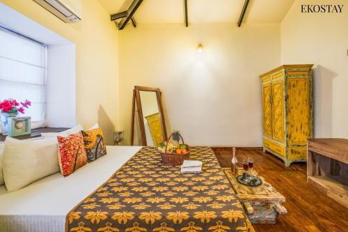 a living room with a bed and a table at EKOSTAY Gold - Oasis Villa in Saligao