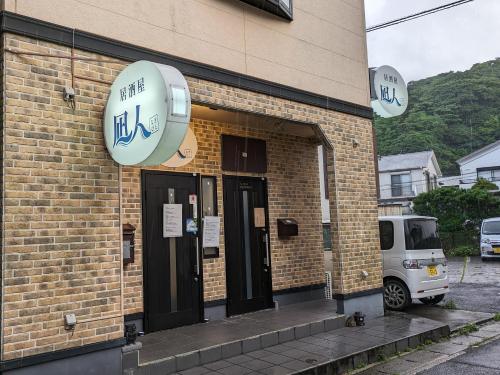 a building with a sign on the side of it at ゲストハウス凪人 in Amami