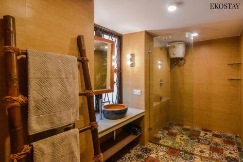 a bathroom with a shower and a toilet and a sink at EKOSTAY Gold - Oasis Villa in Saligao