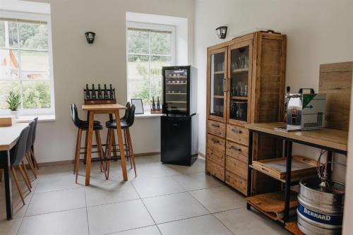 a room with a counter and a table with chairs at Chalupa Bezvětří in Malá Morávka