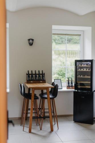 a kitchen with a wooden table and four stools at Chalupa Bezvětří in Malá Morávka