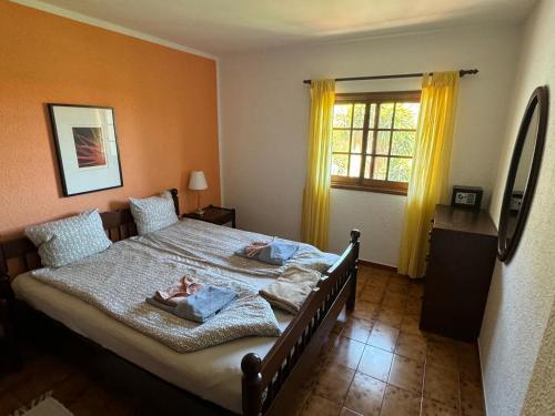 a bedroom with a bed with two pillows and a window at Finca Gerardo Miramar in La Playa Calera