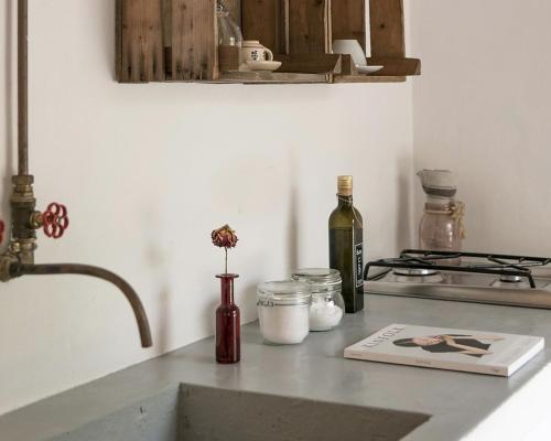 a kitchen counter with a sink and a bottle of wine at Dimora Casanoja in Noci