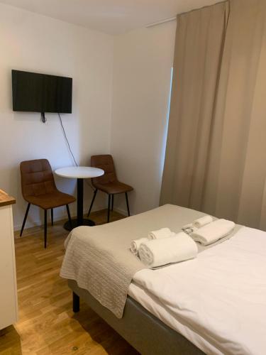 a bedroom with a bed with two chairs and a table at Edsviken Hotell AB in Stockholm