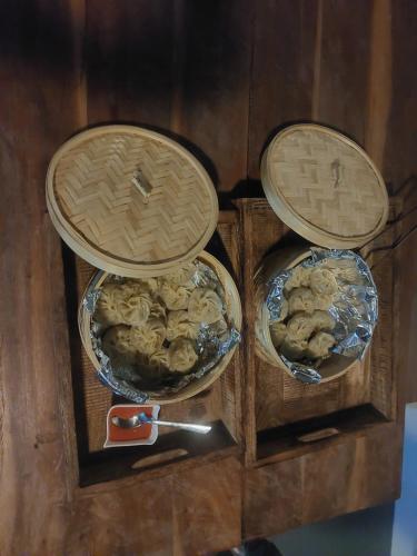 three baskets with food in them on a wooden table at Alinda House Naukuchiatal by THE GHAUR in Bhīm Tāl