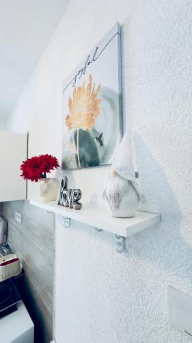 a shelf on a wall with a picture and flowers at WIZARD APARTMENT in Žabljak