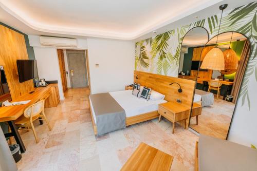 a hotel room with a bed and a desk at Club Tuana Fethiye - All Inclusive in Fethiye
