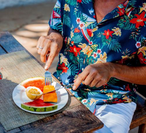 a man sitting at a table with a plate of food at Swahili Palace Zanzibar in Pwani Mchangani