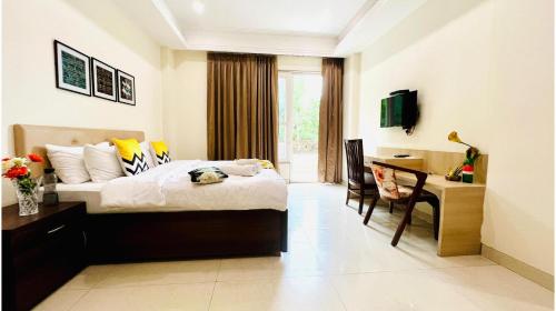 a bedroom with a bed and a desk and a television at BluO Studio2 Golf Course Road - Gym, Terrace Garden in Gurgaon