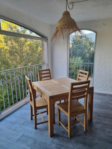 Cette chambre dispose d'un balcon avec une table et des chaises en bois. dans l'établissement Les terrasses de Toucas, à Solliès-Toucas