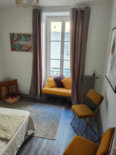 un salon avec un canapé et une fenêtre dans l'établissement Le nid du prince, à Aurillac