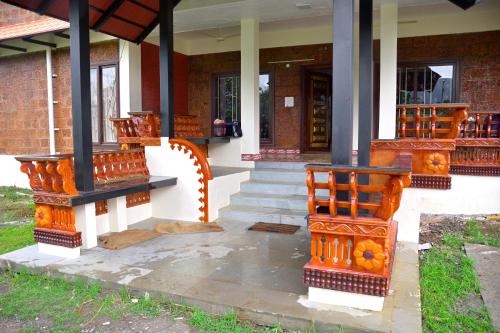 Un porche de una casa con orangetutoriales en él en Lakshmi illam Near Isha Yoga Adiyogi, en Alāndurai