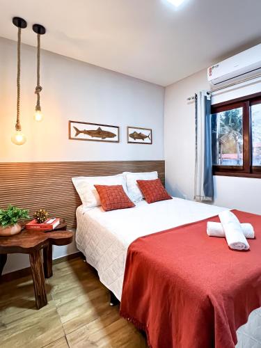 a bedroom with two beds and a table at Kadosh Pipa Hospedagem in Pipa