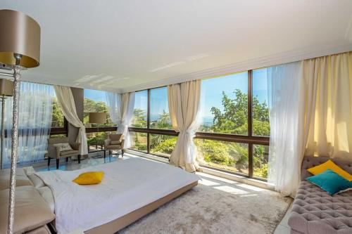 une chambre avec un lit et une grande fenêtre dans l'établissement Villa Emilia, vue mer, Super-Cannes, à Vallauris
