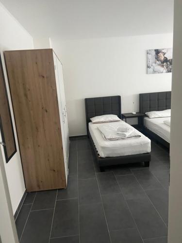a bedroom with two beds and a wooden door at Pension Imhof in Oyten