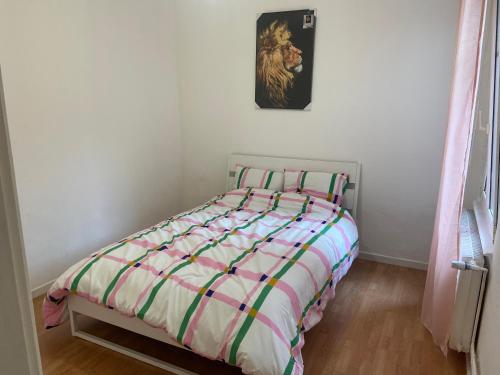 - un lit avec une couette rayée dans une chambre dans l'établissement Appart F2, à Bischheim