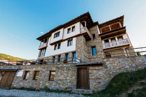 a building on top of a stone wall at Панорама хаус Лещен и еко къщи Дървена и Землянка in Leshten