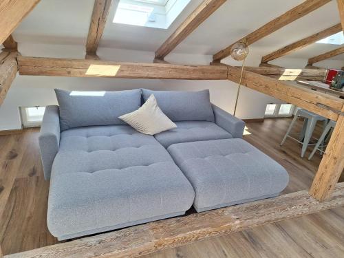 a blue couch in a living room with wooden ceilings at Apartments Salzburg - Bergstraße in Salzburg