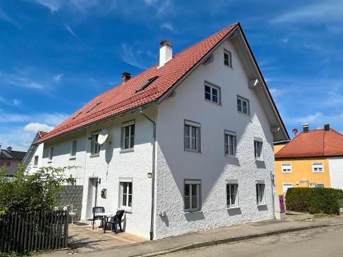 a white house with a red roof at FeWo HoLiDay HouSE Allgäu in Ottobeuren