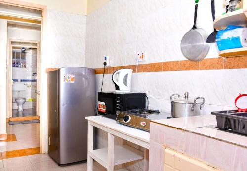 ナイロビにあるLustra Homestay South Bのキッチン(ステンレス製の冷蔵庫、電子レンジ付)