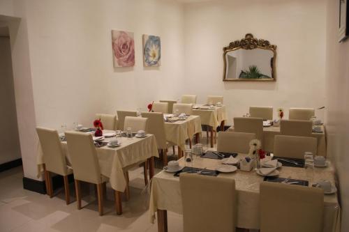 a dining room with tables and chairs and a mirror at The Firs Lodge in Hounslow