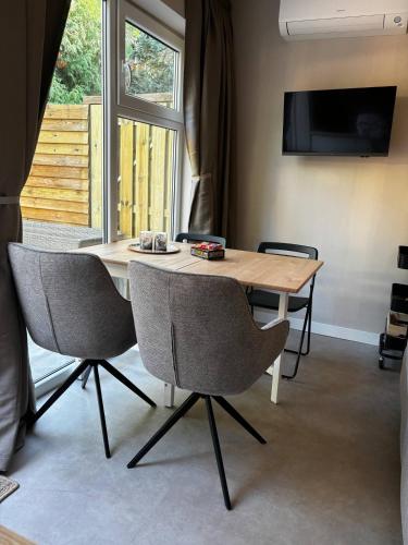 a dining room table with two chairs and a television at Bed and Breakfast Heerenveen Centrum met Privé Sauna en Jacuzzi in Heerenveen