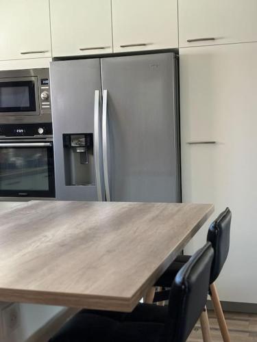 une cuisine avec une table en bois et un réfrigérateur dans l'établissement La Grange Alsacienne, à Westhouse