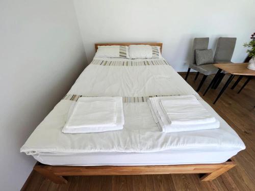 two beds in a room with a table and chairs at Cozy recreation area with a cabin in Šeduva