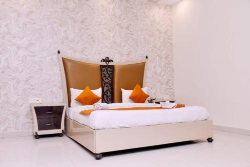 a bedroom with a large bed with orange pillows at Nirmal Hotel And Resort in Bareilly