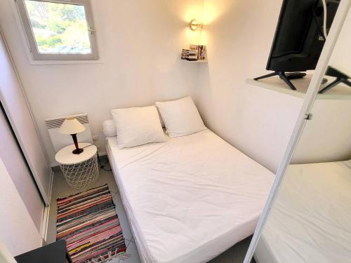 - une petite chambre avec un lit et une télévision dans l'établissement Appartement T2 avec Piscine Gratuite, Parking Privatif, à 200m de la Plage - Animaux Acceptés - FR-1-316-336, à Six-Fours-les-Plages