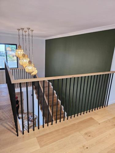 a staircase in a house with a green wall at The Whale's Tale Guesthouse in Hermanus