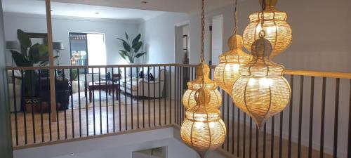 three lights hanging from a railing in a living room at The Whale's Tale Guesthouse in Hermanus