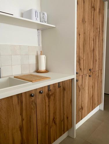 une cuisine avec des armoires en bois et un comptoir dans l'établissement Rénové avec jardin à 5min de la plage, à Saintes-Maries-de-la-Mer