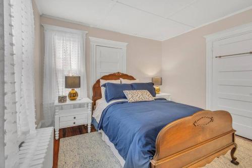 a bedroom with a bed with a blue bedspread and a desk at Classic West Hartford Center Apartment in West Hartford