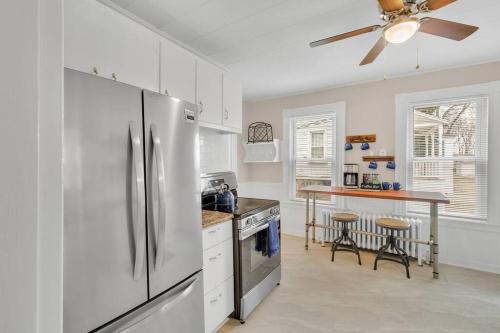 a kitchen with a stainless steel refrigerator and a table at Classic West Hartford Center Apartment in West Hartford