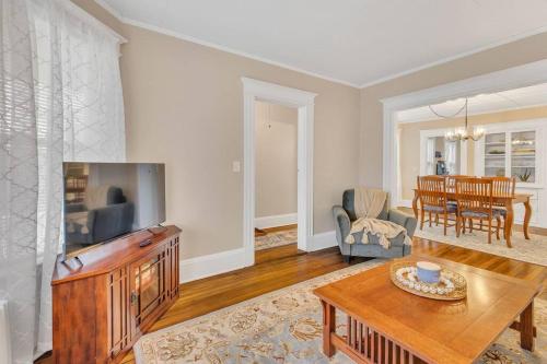 a living room with a television and a table at Classic West Hartford Center Apartment in West Hartford